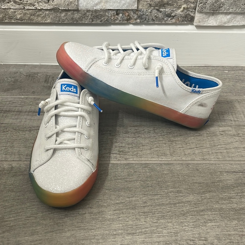 White canvas Keds with glittered tongue. Be the Change & bottom sole in rainbow.